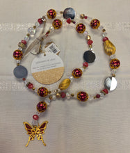 Load image into Gallery viewer, Beaded sun catcher with butterfly charm on a neutral background