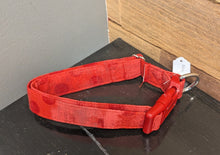 Load image into Gallery viewer, Red dog collar on a dark surface with a wooden cabinet in the background