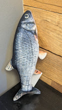 Load image into Gallery viewer, Fish-shaped object leaning against a wooden wall.